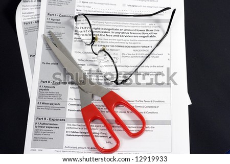 Close up of Real Estate contract with reading glasses and scissors.