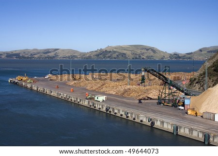 Wood pulp and logs on a wharf ready for loading onto a ship