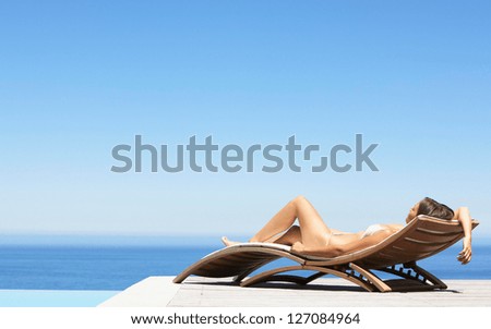 Summer young woman sunbathing in bikini on beach