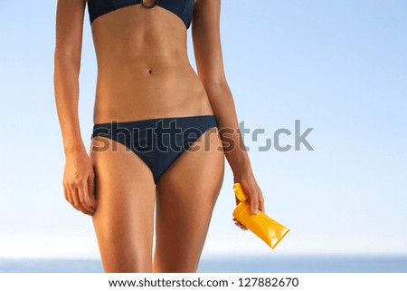 woman applying sun block lotion at beach