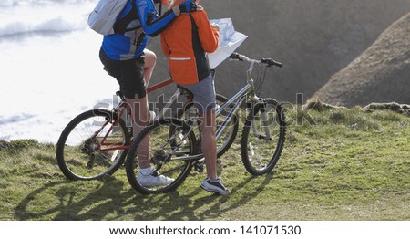 Couple riding looking at map on bike