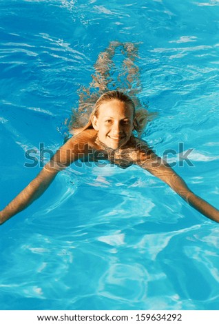 Sexy young girl posing at clear blue swimming pool