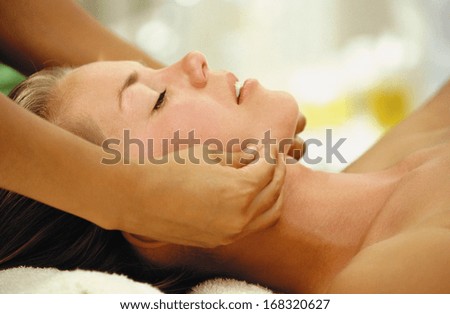 An attractive caucasian woman lying down on a massage bed