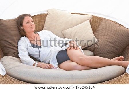 Relaxing woman sitting comfortable in sofa lounge chair