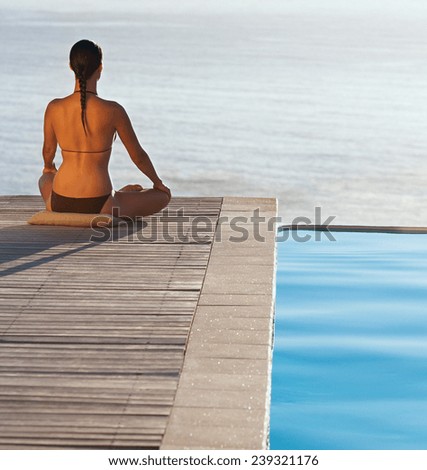 Young Woman with Long Black Hair Doing Yoga at the Poolside