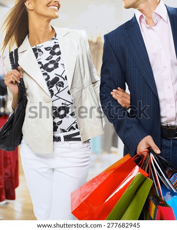 Portrait of young happy smiling woman and man with shopping bags