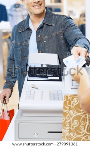 man at the supermarket giving  Euro to the cashier