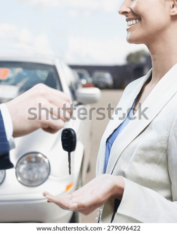 view of man in car dealership giving car keys to client