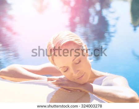 Young slim fit tanning woman having fun near pool