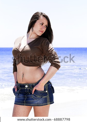 Girl in jeans skirt at seaside with the sea as background
