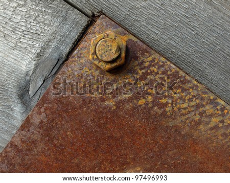closeup of metal plate on wood plate with bolt. background texture