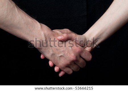 Handshake between woman and man, on black background