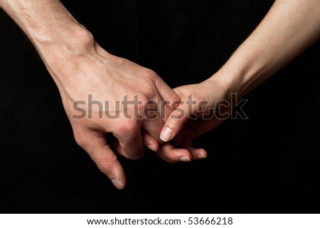 Man and woman holding hands, on black background