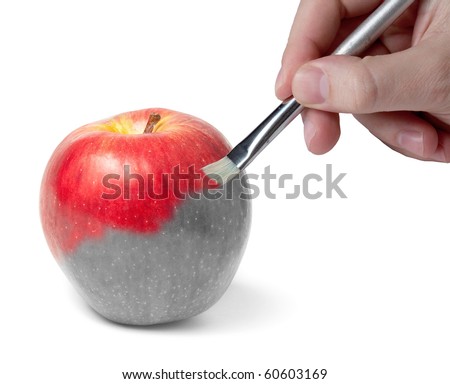 Male hand painting a fresh red wet apple which is partly black and white and partly colored