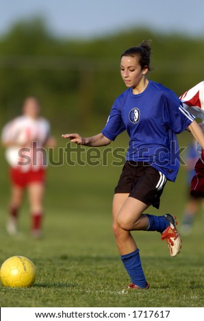 Teen Girl soccer player about to make a move with yellow soccer ball