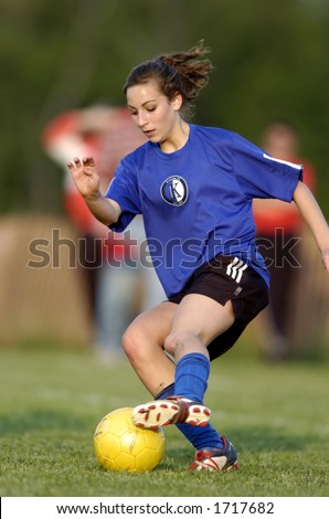 Teen girl soccer player makes a move with a yellow soccer ball