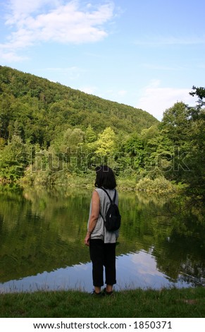 Breathing pause - Female hiking looking out on a quiet mountain lake