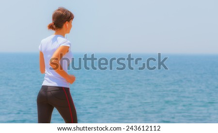 Runner girl - athlete running at seaside in summer, woman fitness, healthy lifestyle