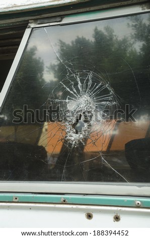 Cracked glass Shattered bus glass window that resulted from a thrown stone by a pedestrian