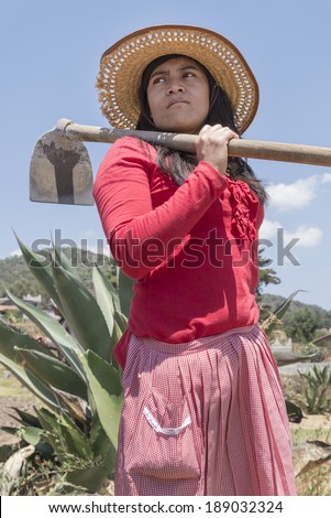 Mexican female farmer This proud farmer is carrying a hoe while glancing at the work to be done