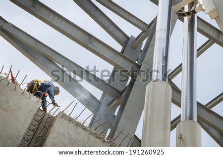 Welding metal columns Welder soldering metal girders in a structure high above