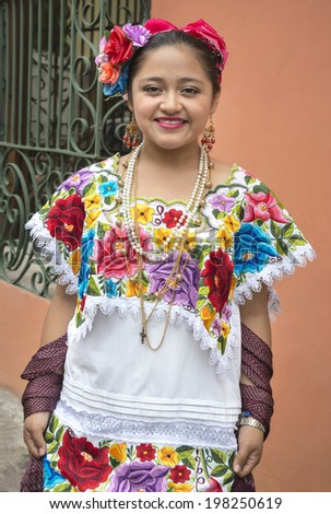 Colorful Mayan girl in Yucatan This native woman from the city of Merida in Yucatan, Mexico poses gladly to show its vibrant dress sewn by hand in a very colorful fashion