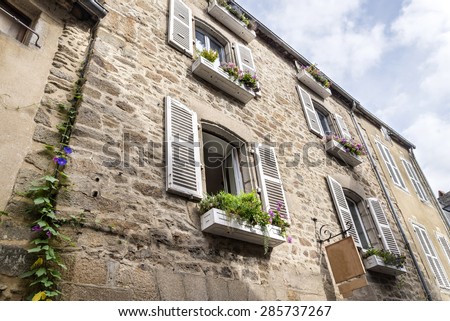 A beautiful balcony on a riverside house in the medieval town of Dinan in Brittany, France\
Traditional decorative flowers on around house in Normandy, France