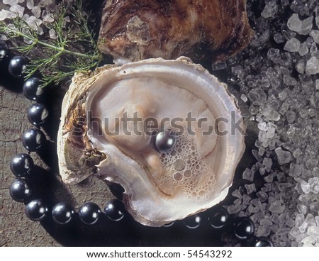 Open oyster revealing a grey pearl inside