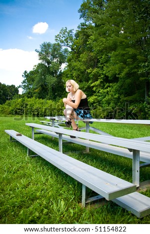 young woman sitting in alone park sad