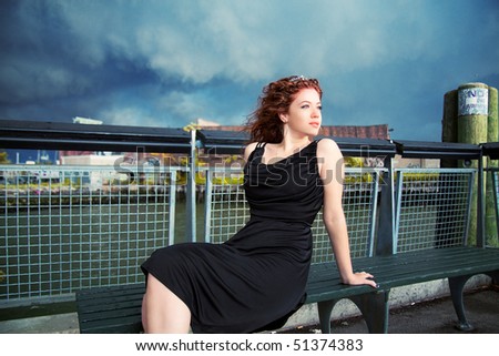 young redhead woman sitting by the water