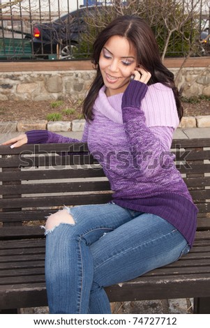 young hispanic college student talking on her cell phone to her friends