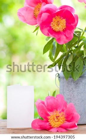 Pink peonies  in metal vase and empty card for letter
