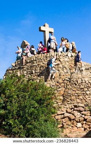 BARCELONA, SPAIN - OCT 19,2014: Tourists on Hill of Three Crosses ormonumentto Calvary in Park Guell.Park Guell is famous architectural town artdesignedby Antoni Gaudi and built in years 1900 to 1914