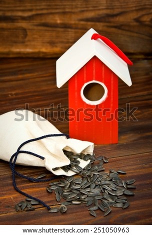 Red wooden bird house with seed