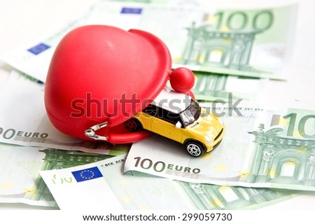 Red wallet, toy car and euro