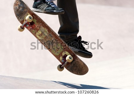 Close up of a skateboarders feet while skating on concrete at the skate park.
