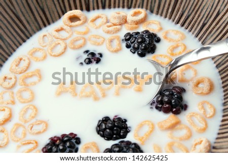 The words HAPPY spelled out of letter shaped cereal pieces floating in a milk filled cereal bowl.