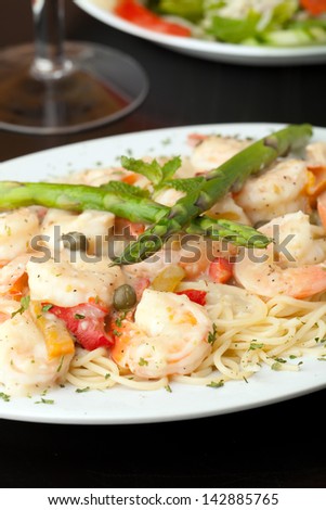 Shrimp Scampi with Spaghetti - A delicious shrimp scampi pasta dish with antipasto salad in the background.