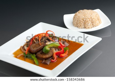 A beautifully presented dish of Thai food with mixed vegetables beef and brown rice.