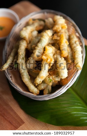 Thai style appetizer of fried tempura asparagus with dipping sauce.