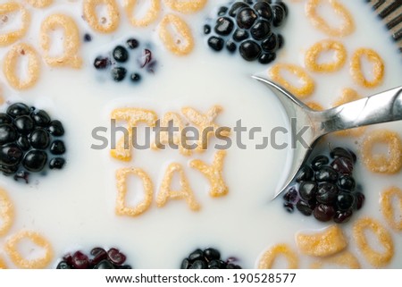 The words TAX DAY spelled out of letter shaped cereal pieces floating in a milk filled cereal bowl.