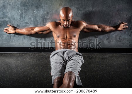 Portrait of a lean toned and ripped muscle fitness man under dramatic low key lighting.