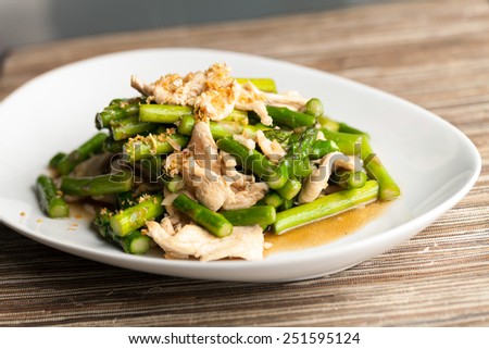 Freshly prepared Asian style chicken and asparagus stir fry with garlic.