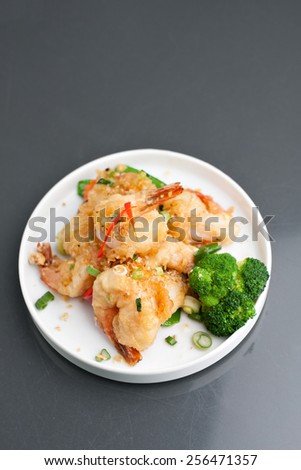 Thai style honey shrimp dish presented beautifully on a round white plate with copy space above.