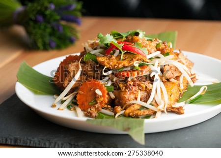 Thai style radish cakes dish with chicken.  Also referred to as turnip cakes. Shallow depth of field.
