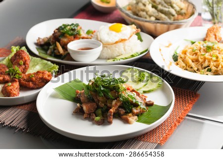 Variety of Thai food and stir fry dishes.  Shallow depth of field.