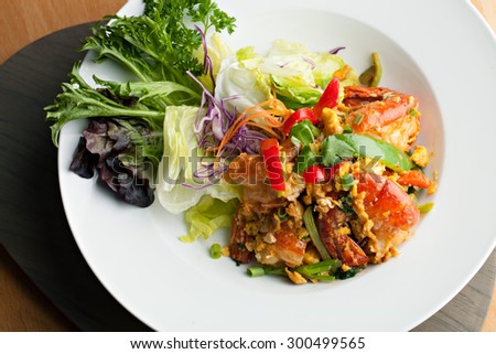 Thai jumbo shrimp salad on a round white plate. Shallow depth of field.