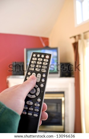 A remote control in hand - shallow depth of field with focus on the remote.