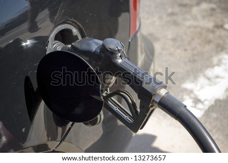At the gas pump - filling up the tank.