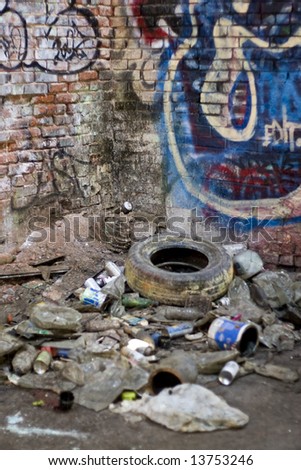 An abandoned area that is covered with trash and street graffiti.  This makes an excellent background or backdrop.  Shallow depth of field.